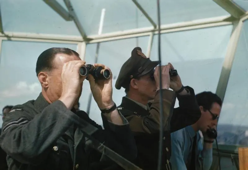 RAF controllers in the Prestwick tower cab looking out through binoculars, 1944
